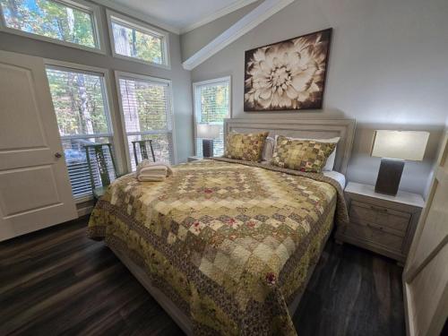 a bedroom with a bed with a comforter at Romantic Getaway Hot Tub Keyless Arrival in Broken Bow