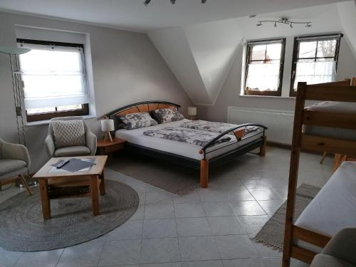 a bedroom with a bed and a chair and a table at Die kleine Feine in Olmscheid