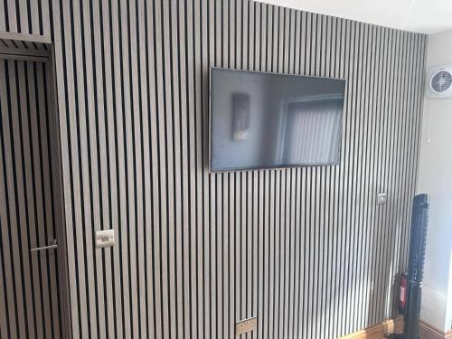 a television on a wall in a room at Beautiful 1-Bed studio in Penrith in Penrith
