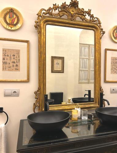 a bathroom with a large mirror and a sink at Casona de Santa Ana in Cuevas Bajas