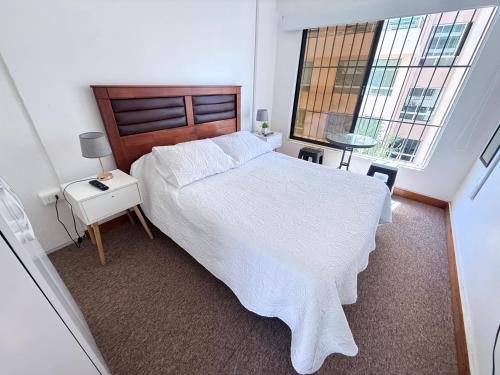 a bedroom with a large bed and two windows at Hostal EntreOrientes in Viña del Mar