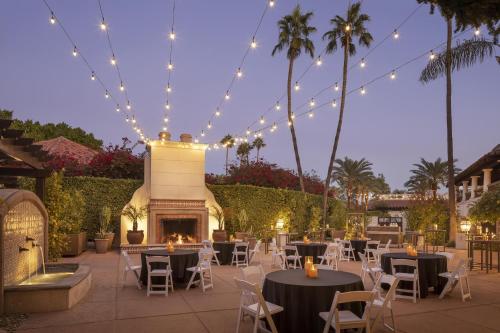 a patio with tables and chairs and a fireplace at The Scottsdale Resort & Spa, Curio Collection by Hilton in Scottsdale
