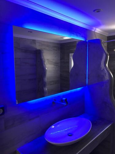 a bathroom with a sink with a blue light at Porto Blue Heaven in Porto Rafti