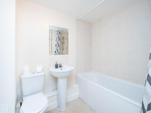 a white bathroom with a toilet and a sink at Crawley 2 bed flat with Parking in Crawley