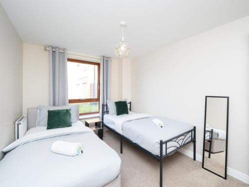 a room with two beds and a mirror at Crawley 2 bed flat with Parking in Crawley