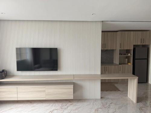 Una sala de estar con un televisor en la pared. en Appartement Horizon 8, en Abiyán