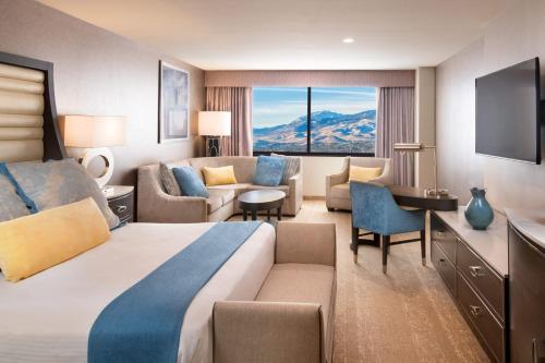 a bedroom with a large bed and a living room at Grand Sierra Resort and Casino in Reno