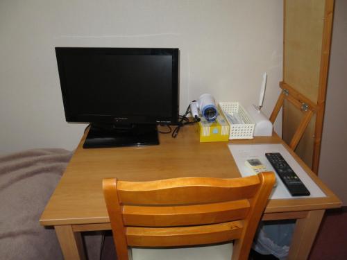a desk with a computer monitor and a telephone at Belaire Ogata - Vacation STAY 32397v in Sanuki
