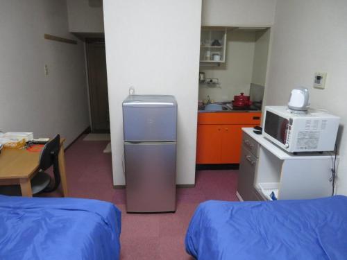 a room with a kitchen with a refrigerator and a microwave at Belaire Ogata - Vacation STAY 32397v in Sanuki