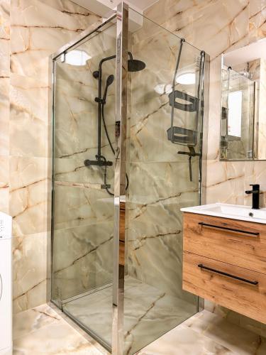 a shower with a glass door in a bathroom at Rumia Apartment by JumpInHere in Rumia