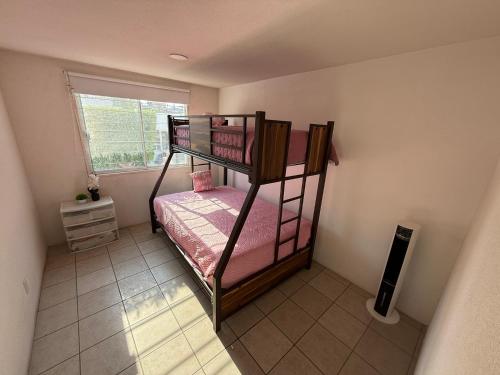 zwei Etagenbetten in einem kleinen Zimmer mit Fenster in der Unterkunft Casa SkiPhoe in Panchimalco