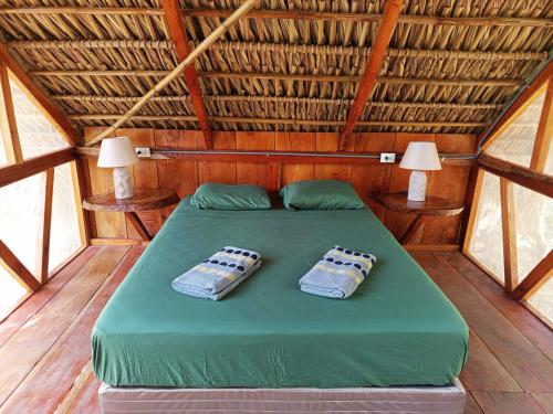 a bedroom with a green bed with two pillows on it at Cielo y Tierra in Santa Cruz