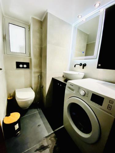 a bathroom with a washing machine and a sink at Phoenix Garden Apartments -1- in Athens