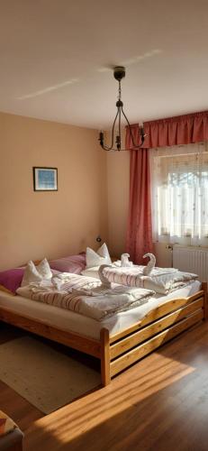a bedroom with a large bed in front of a window at Lukács Ház in Bük
