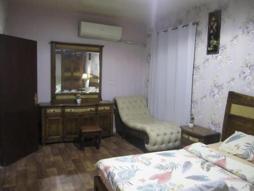 a bedroom with two beds and a desk and a mirror at العين الهيلي المصباح ب ب 9 in Al Ain