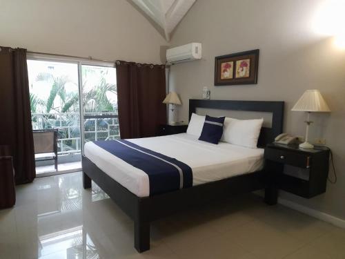 a bedroom with a bed and a large window at Christar Villas Hotel in Kingston