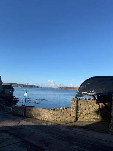 Blick auf ein Gewässer mit einer Steinmauer in der Unterkunft Fairview in Lerwick