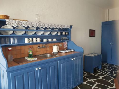 a kitchen with blue cabinets and a sink at Aegean Home - Studios & Apartments in Masouri