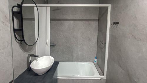a bathroom with a tub and a toilet and a sink at Atico moderno en Langreo in Langreo