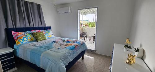 a bedroom with a bed and a table and a window at Carrasco Apartamentos in Nagua