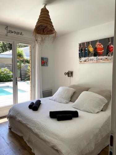 a bedroom with a bed with two black towels on it at La tranquille marée , à 5 min des plages in Soorts-Hossegor