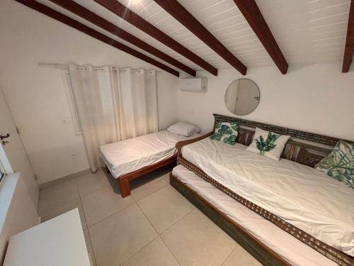 a room with two beds and a mirror in it at Apartamento em Maresias a 100 metros da praia in Maresias