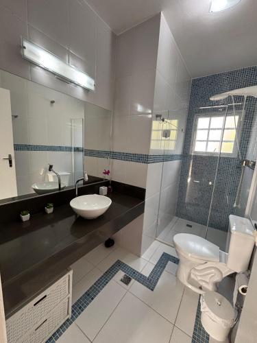 a bathroom with a toilet and a sink at Apartamento em Maresias a 100 metros da praia in Maresias