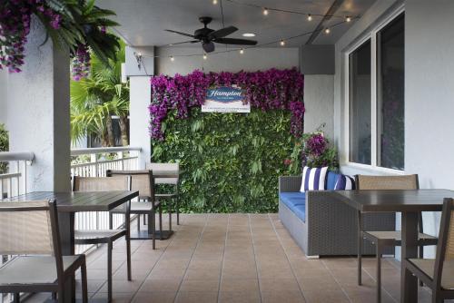 a patio with a green wall with purple flowers at Hampton Inn Fort Lauderdale Downtown Las Olas Area in Fort Lauderdale