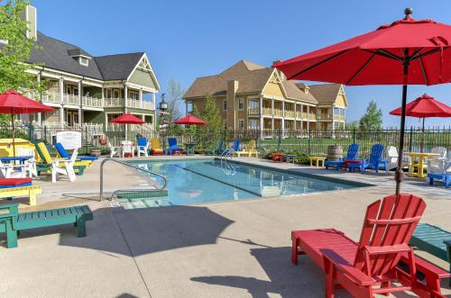a swimming pool with chairs and a red umbrella at Hilton Grand Vacations Club Blue Mountain Canada in Blue Mountains