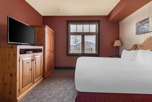 a bedroom with a bed and a flat screen tv at Hilton Grand Vacations Club Blue Mountain Canada in Blue Mountains