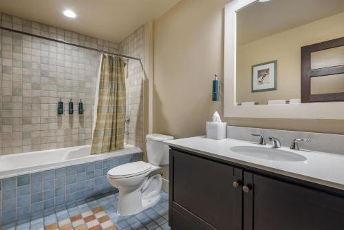 a bathroom with a sink and a toilet and a tub at Hilton Grand Vacations Club Blue Mountain Canada in Blue Mountains