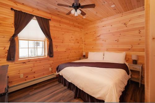 a bedroom with a bed in a log cabin at Presidential Mountain Resort in Bethlehem