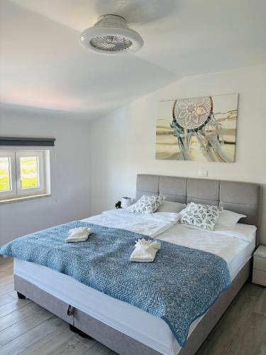 a bedroom with a large bed with a blue comforter at Apartment Aurora in Ankaran
