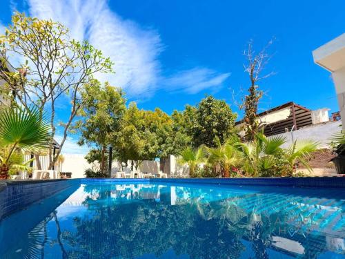 a swimming pool in a villa with blue sky and trees at Shared Pool Oasis Near Malecon BBQ Wi-Fi in La Paz