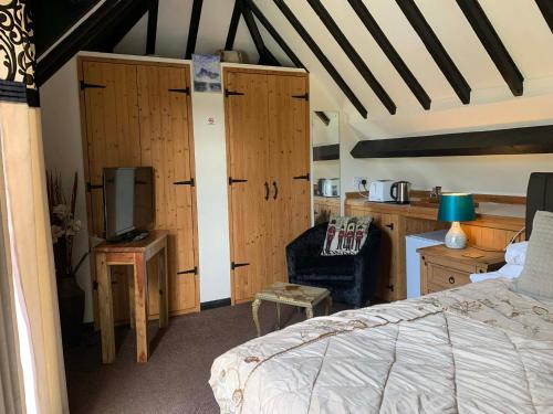 a bedroom with a bed and a desk and a tv at Broadwalk 6 in Coltishall
