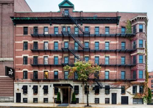 a large red brick building with a tree in front of it at Hotel Ivy Boston Common in Boston