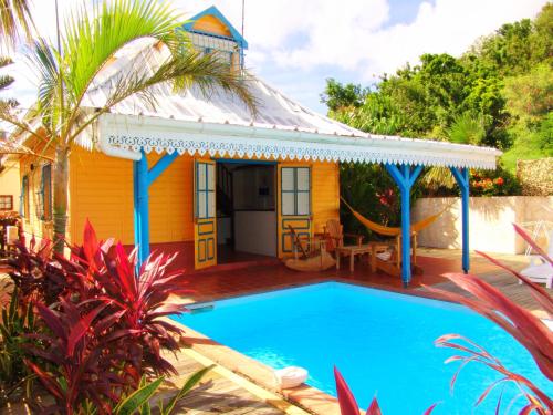 a yellow house with a swimming pool in front of it at Les Villas Créoles de Sainte-Anne in Sainte-Anne