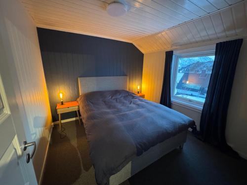 a bedroom with a large bed and a window at Northbound Sea View Retreat in Sortland
