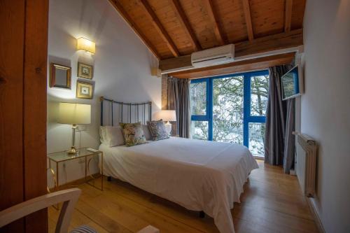 a bedroom with a bed and a large window at Casa Perfeuto Maria in Cabana Moura 