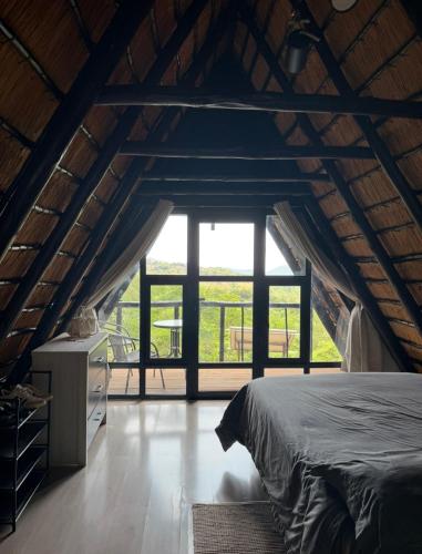 a bedroom with a bed and a large window at Picturesque 82 in Buffelspoort