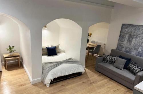a bedroom with a bed and a couch at Gorgeous little gem in London
