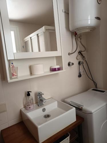 a bathroom with a sink and a mirror and a toilet at Casa Angeles in Castell de Ferro