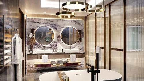 a bathroom with two sinks and two mirrors at Conrad Bahrain Financial Harbour in Manama