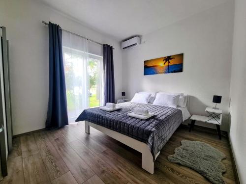 a bedroom with a bed and a large window at House Beachfront Delight in Neviđane