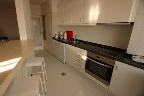 a kitchen with white cabinets and a counter top at Porto Riverside in Porto