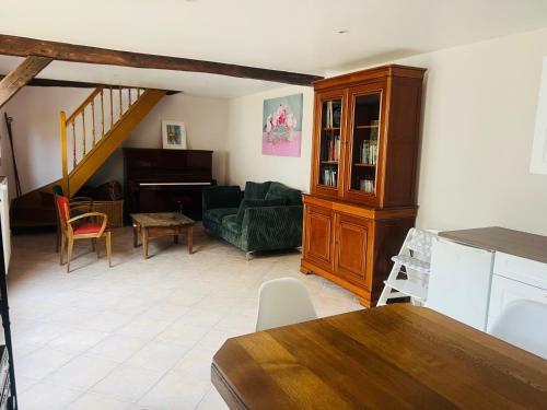 a living room with a green couch and a piano at La maisonnette in Warmeriville