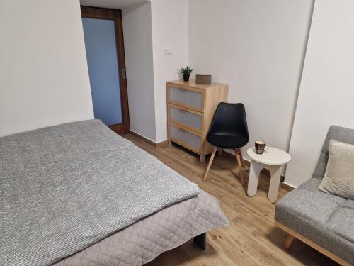 a bedroom with a bed and a chair and a dresser at Ve dvoře in Výrovice