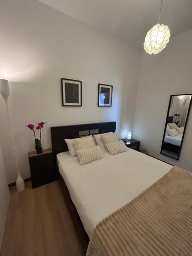 a bedroom with a large white bed and a lamp at Boavista Apartments in Paredes de Coura
