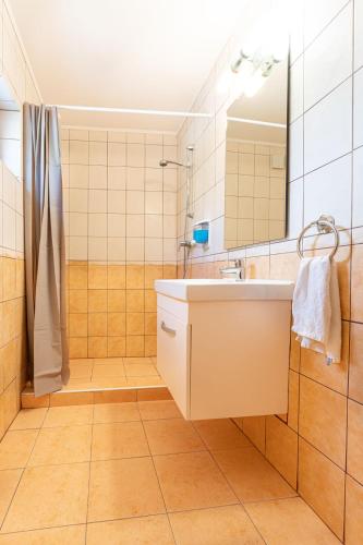 a bathroom with a sink and a mirror at Varázskő Apartman in Gyula