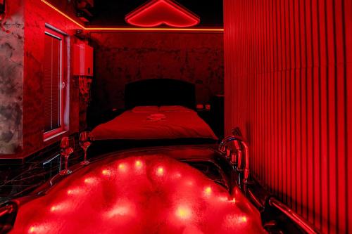 a red room with a bed and a red tub at Love & Jacuzzi in Bucharest